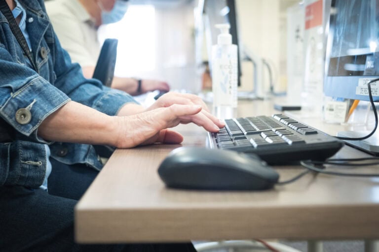 Des mains tapent sur un clavier d'ordinateur.